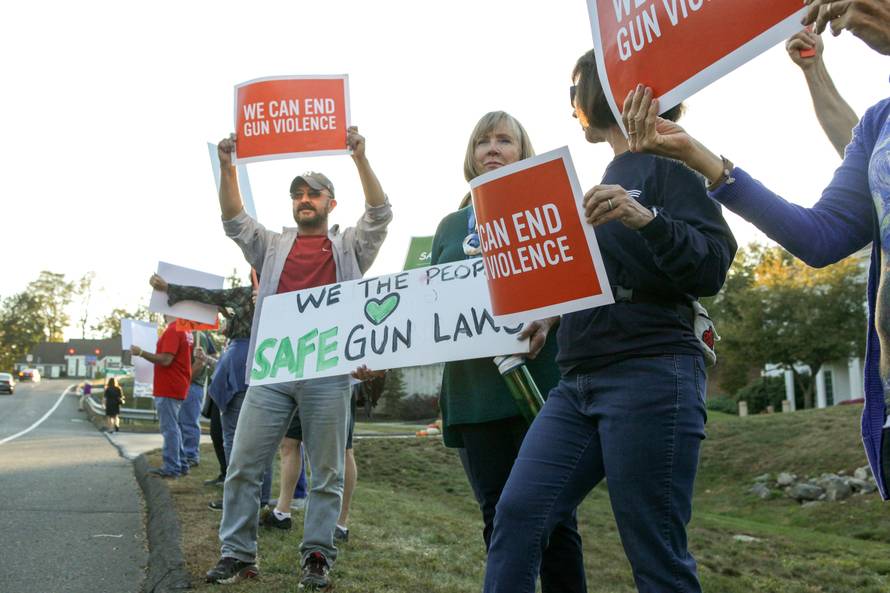 FILE PHOTO: Mourners hold signs during a solidarity vigil in memory of victims of Las Vegas' Route 91 Harvest music festival mass killing, in Newtown
