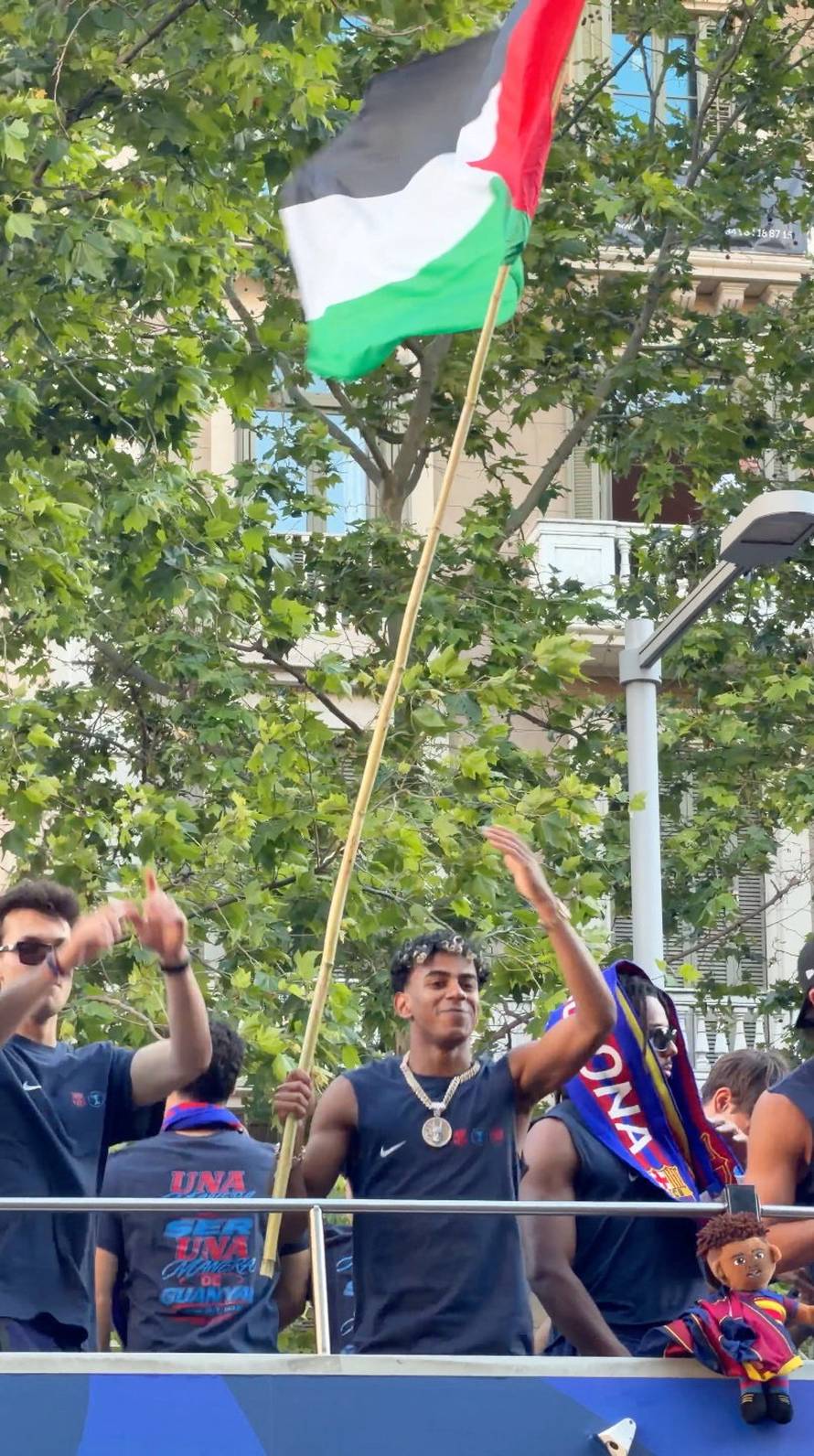 Lamine Yamal waves a Palestinian flag during FC Barcelona's open-top victory parade to celebrate winning LaLiga, in Barcelona