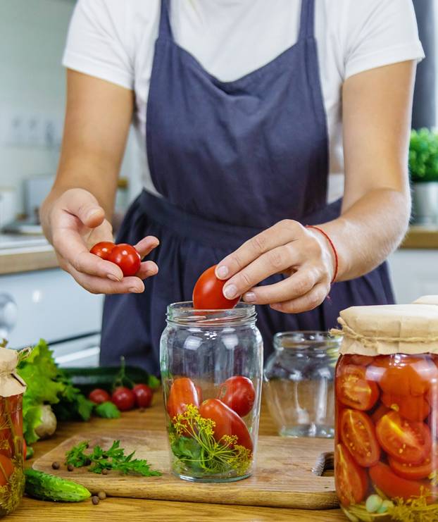 Woman,Canning,Vegetables,In,Jars,In,The,Kitchen.,Selective,Focus.