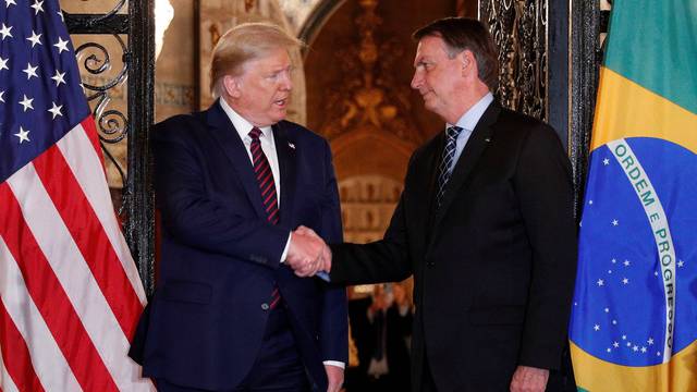 U.S. President Donald Trump shakes hands with Brazilian President Jair Bolsonaro before attending a working dinner at the Mar-a-Lago resort in Palm Beach, Florida