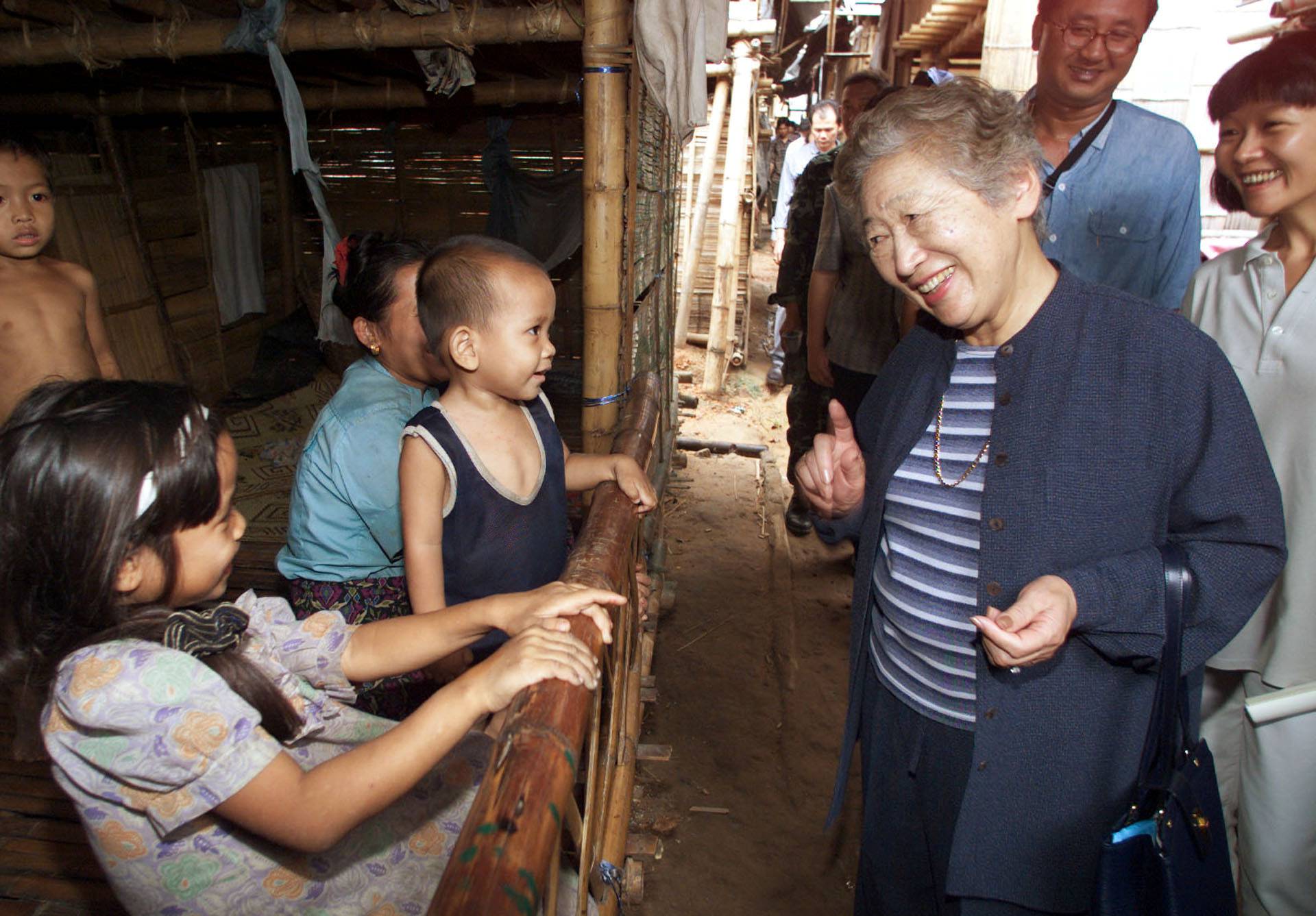 FILE PHOTO: United Nations High Commissioner for Refugees Sadako Ogata talks to a young refugee family from Myanmar at their camp in Thailand