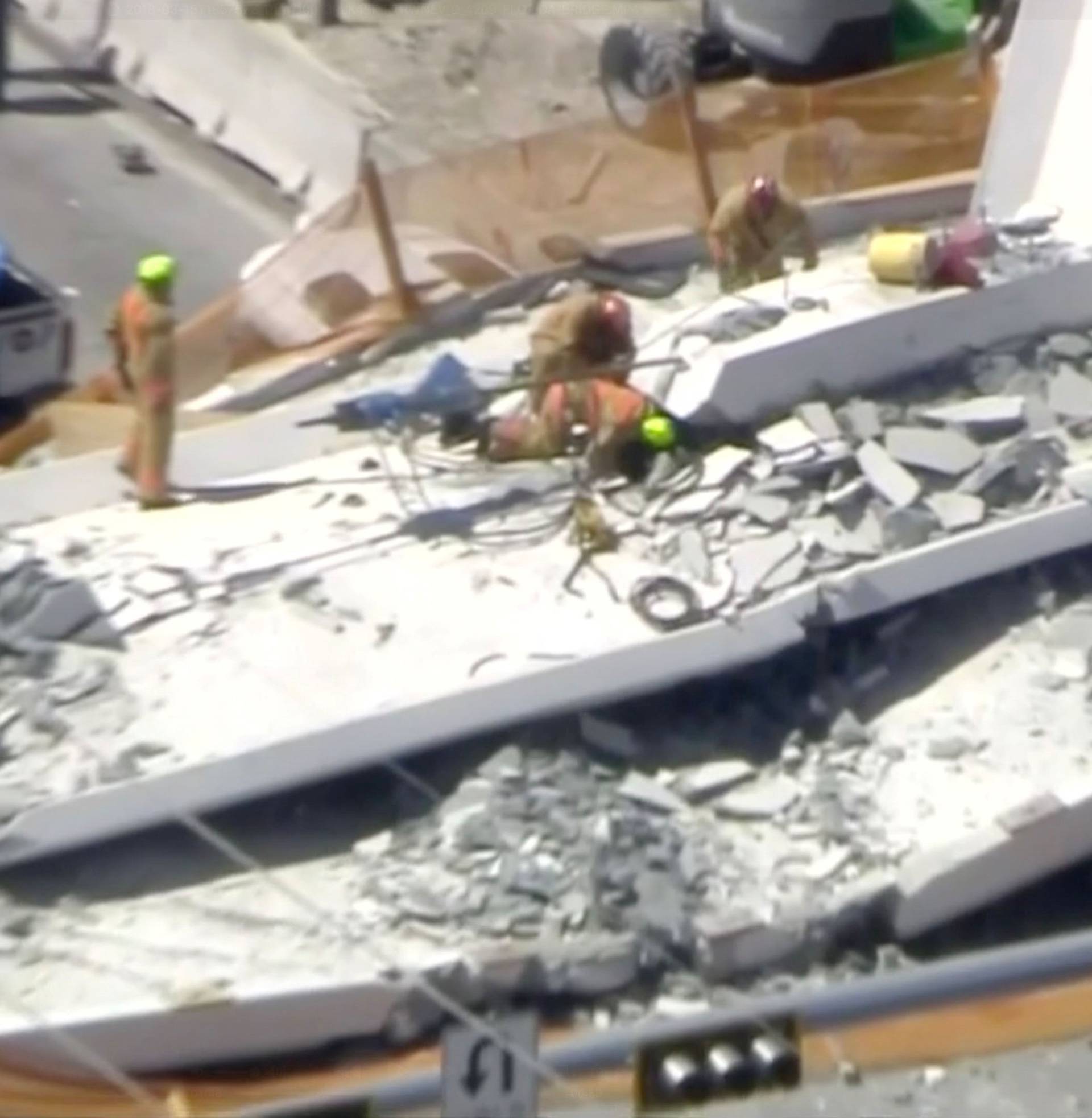 Emergency crews look for victims at the scene of a collapsed pedestrian bridge at Florida International University in Miami, Florida