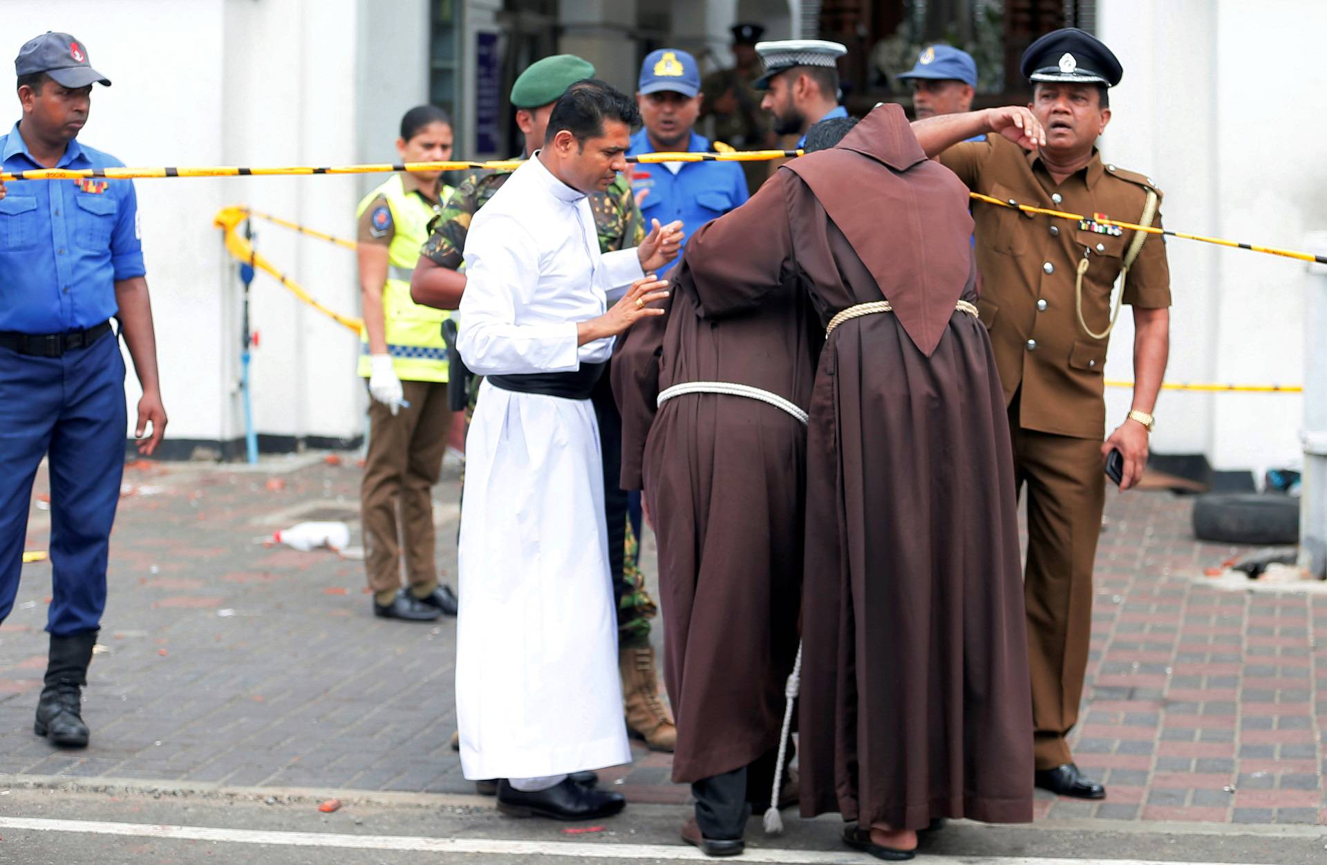 Priests walk into the St. Anthony's Shrine, Kochchikade church after an explosion in Colombo