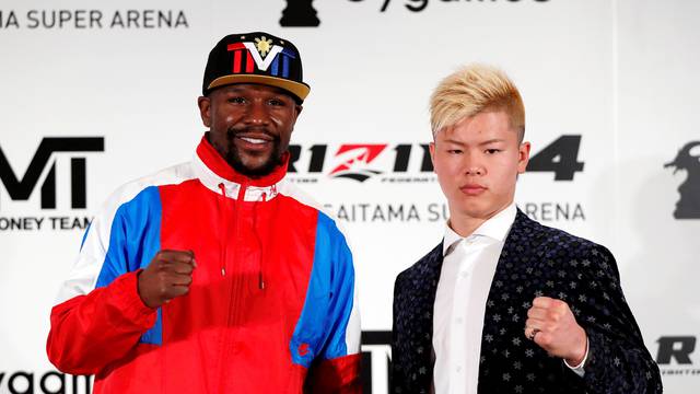 Boxer Floyd Mayweather Jr. of the U.S. poses for a photograph with his opponent Tenshin Nasukawa during a news conference in Tokyo