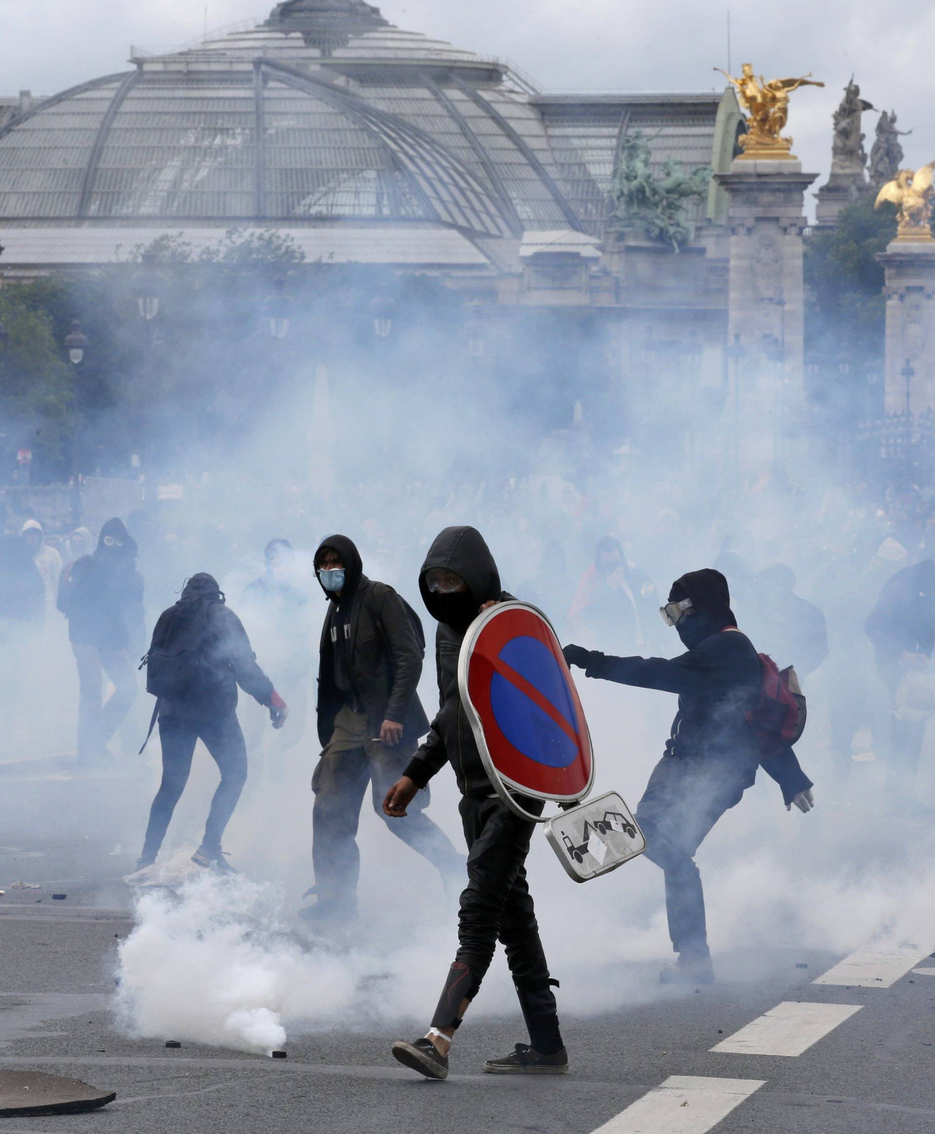 Masked youths face off with French police and gendarmes during a demonstration in Paris as part of nationwide protests against plans to reform French labour laws