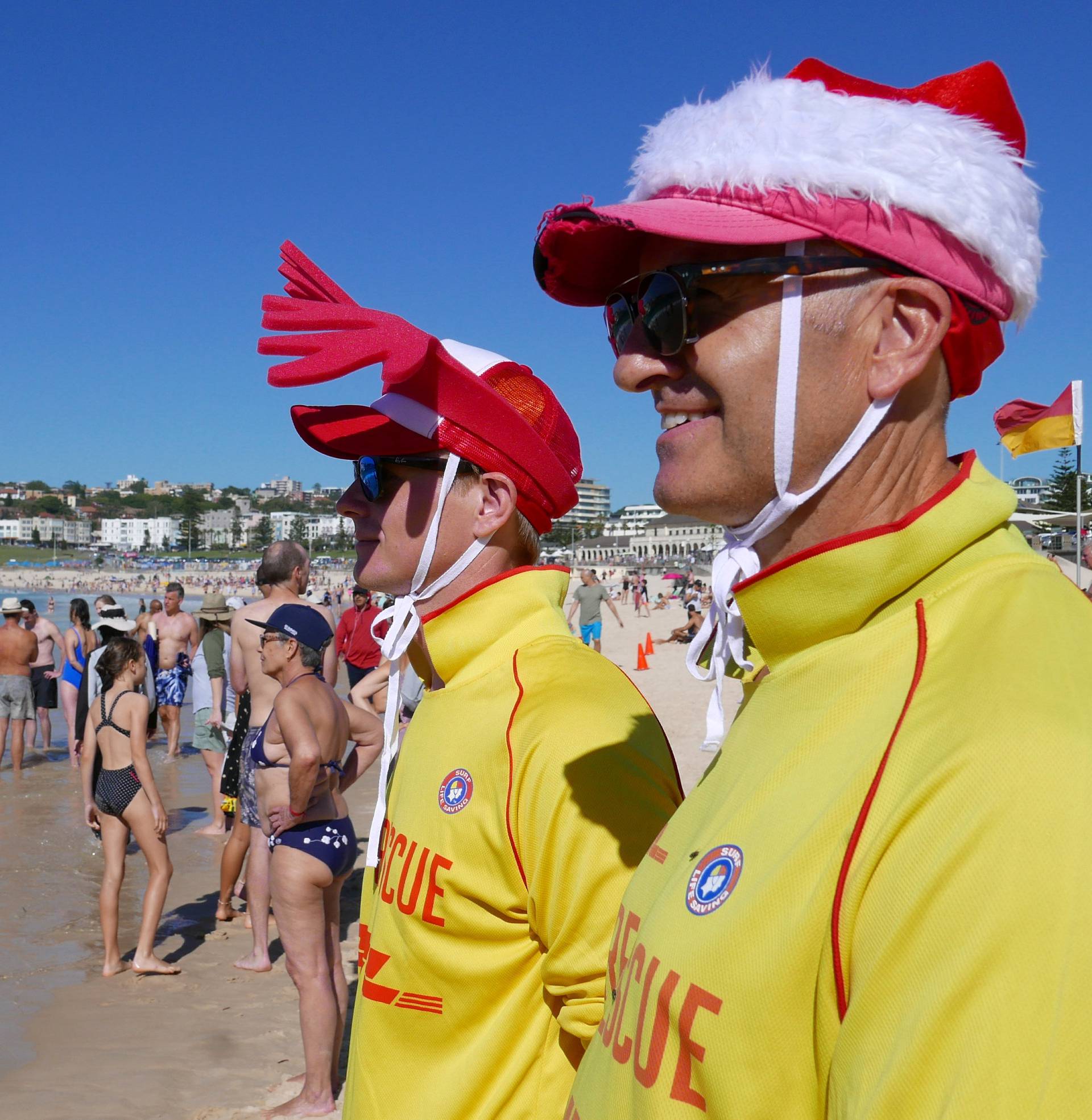 Simon (L) and Victor (R), volunteer life guards from North Bondi Surf Life Saving Club, keep an eye on swimmers enjoying Christmas day on Bondi Beach