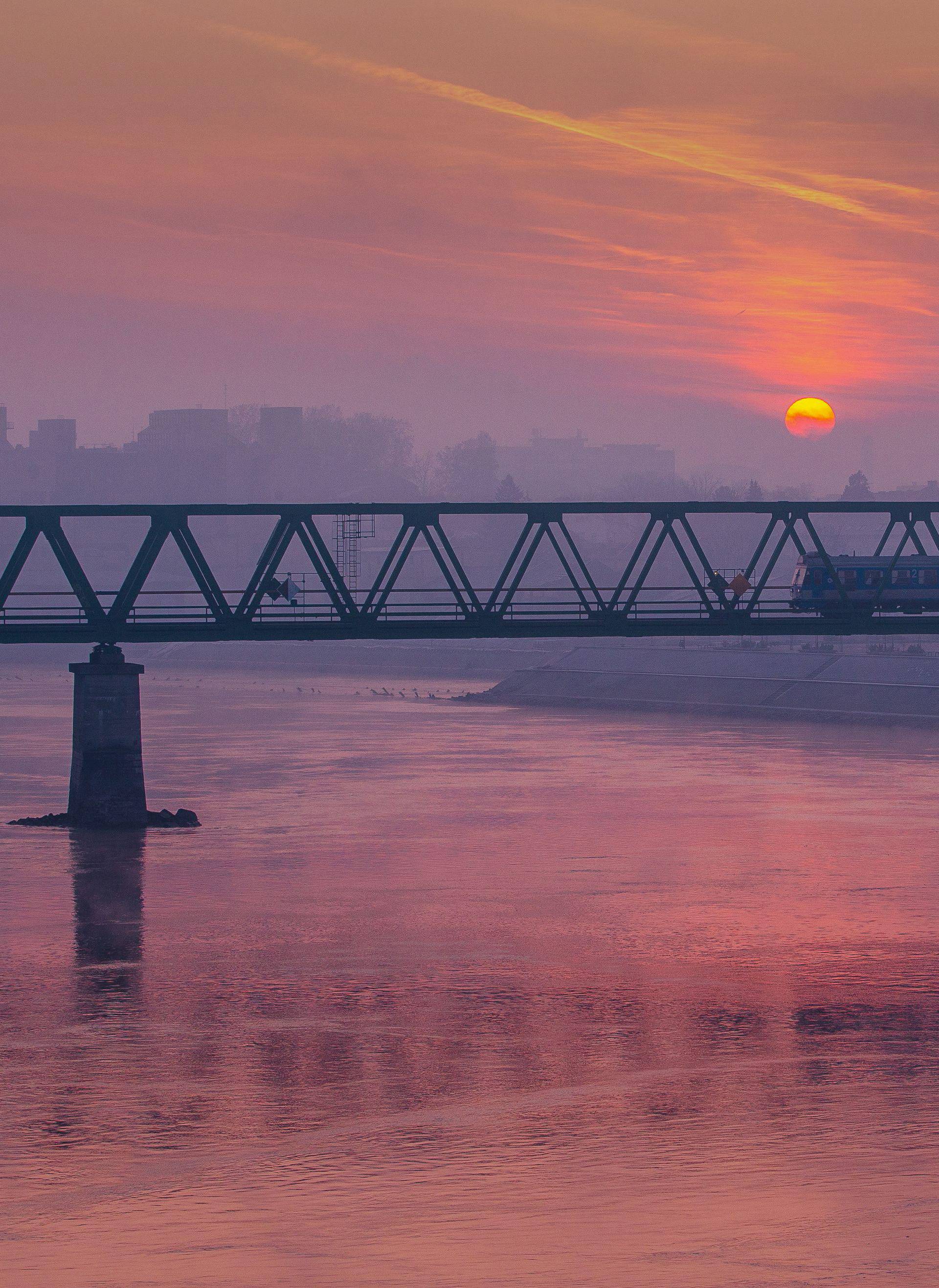 Izlazak sunca nad Dravom i željezničkim mostom u Osijeku