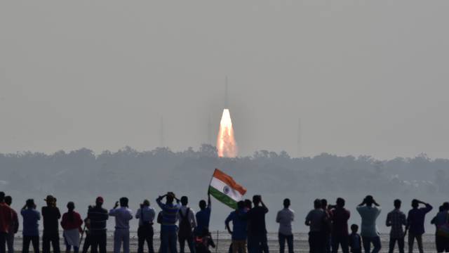 People watch as India's PSLV-C37 carrying 104 satellites in a single mission lifts off from the Satish Dhawan Space Centre in Sriharikota