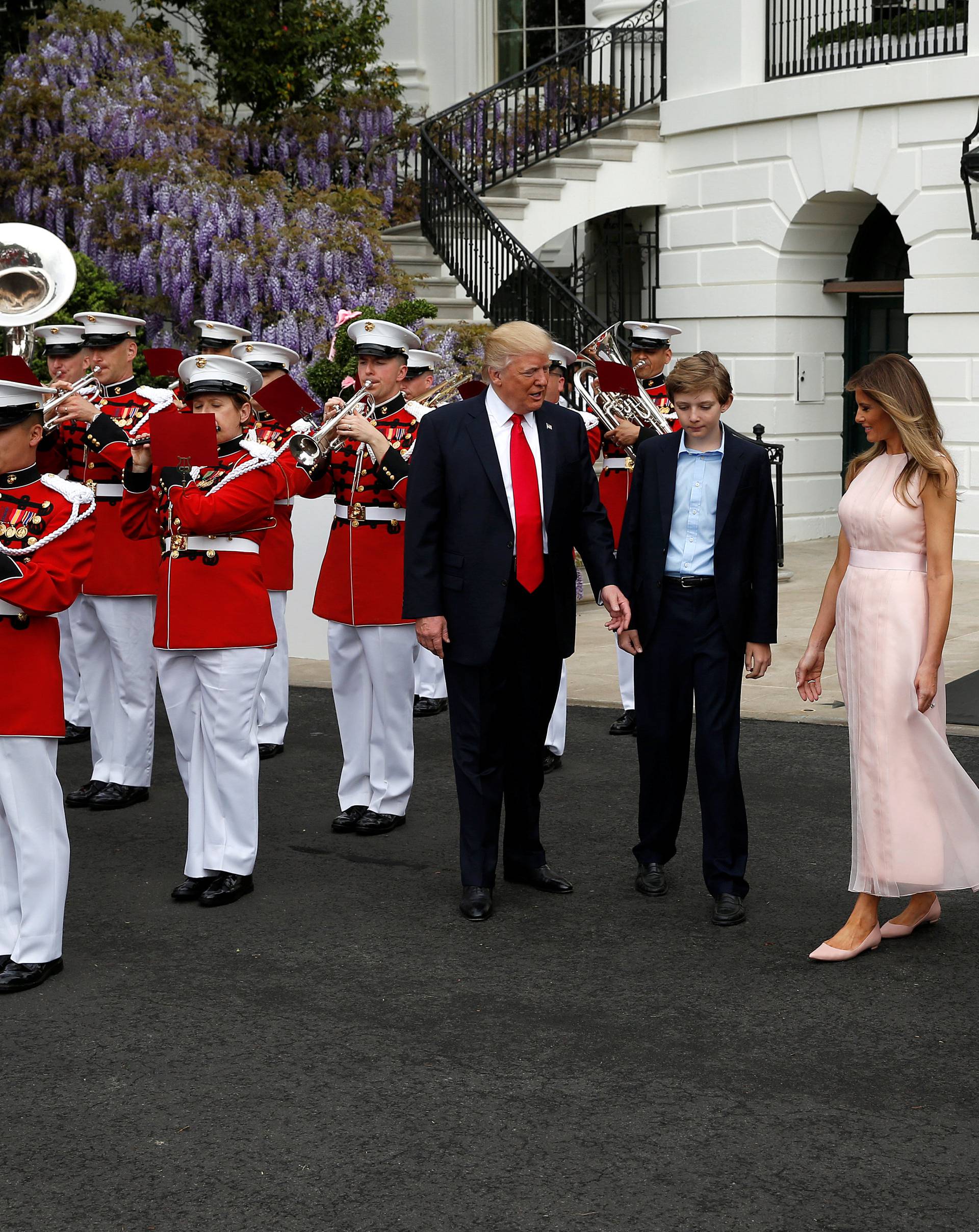 U.S. President Donald Trump, U.S. first lady Melania Trump and the their son Barron listen as a military band plays during the 139th annual White House Easter Egg Roll on the South Lawn of the White House in Washington