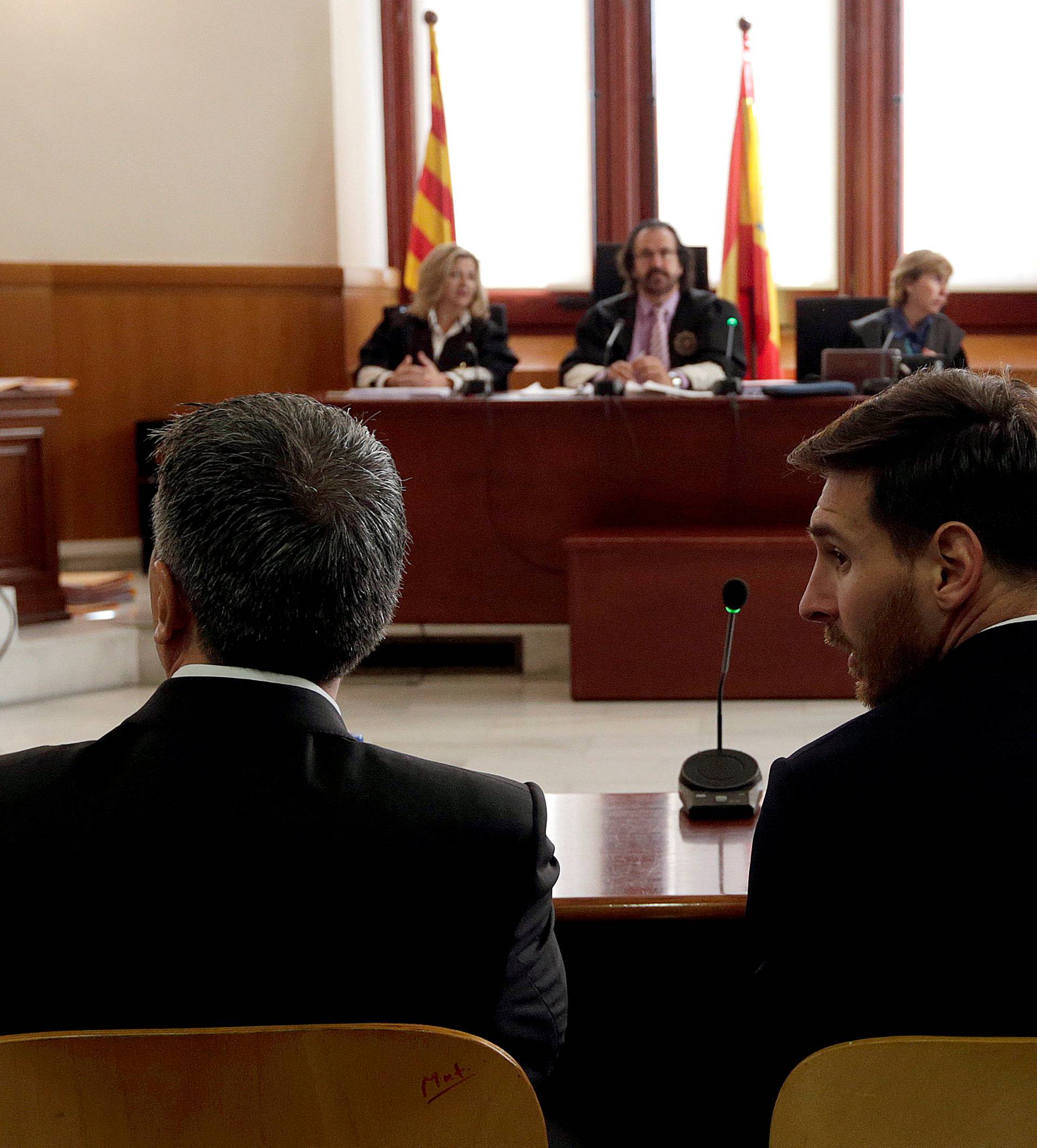 Barcelona's Argentine soccer player Lionel Messi sits in court with his father Jorge Horacio Messi during their trial for tax fraud in Barcelona
