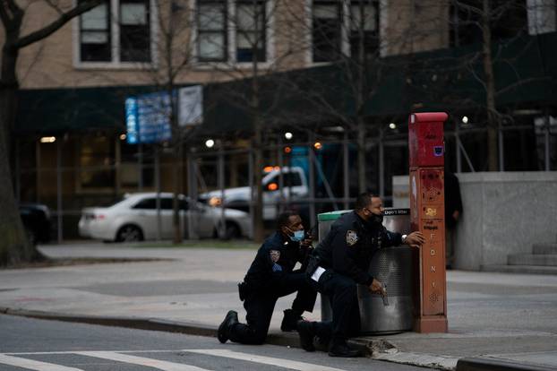 Police officers guard while a man is shooting outside the Cathedral Church of St. John the Divine in Manhattan