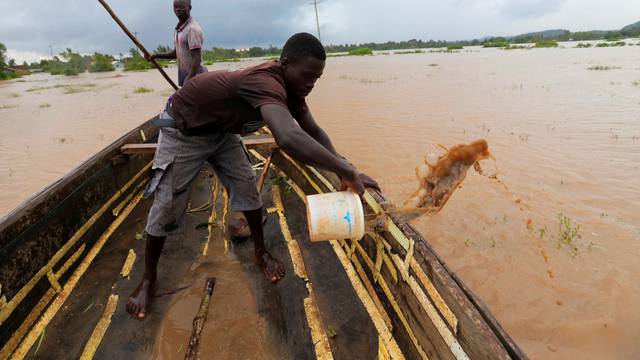 A man removes flood water from a boat as residents evacuate from their homes after River Nzoia burst its banks and due to the backflow from Lake Victoria, in Buyuku village of Budalangi