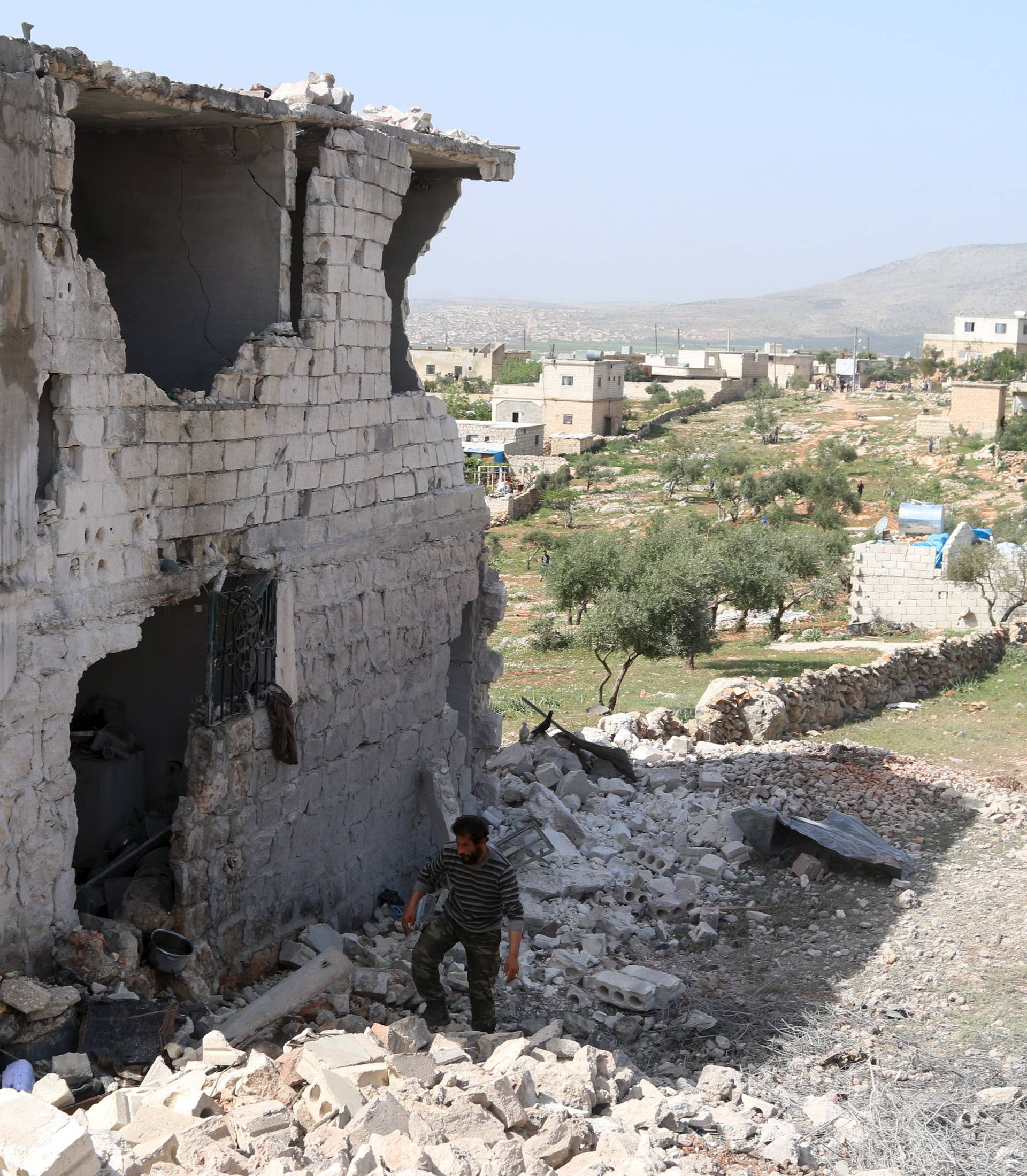 A man inspects damage after an airstrike in the rebel-held town of Turmanin, in Idlib Governorate