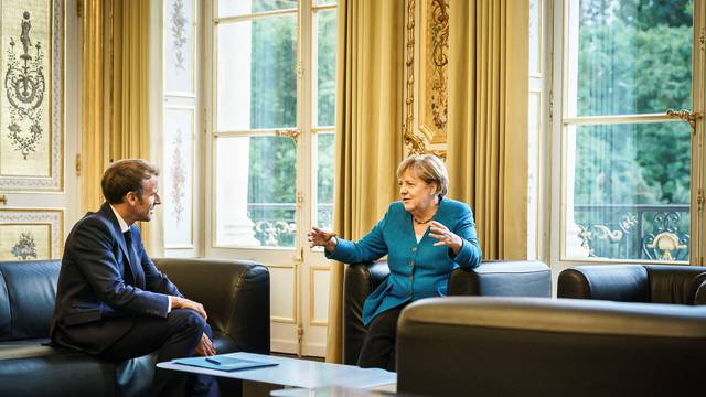 French President Emmanuel Macron talks to German Chancellor Angela Merkel at the Elysee Palace in Paris