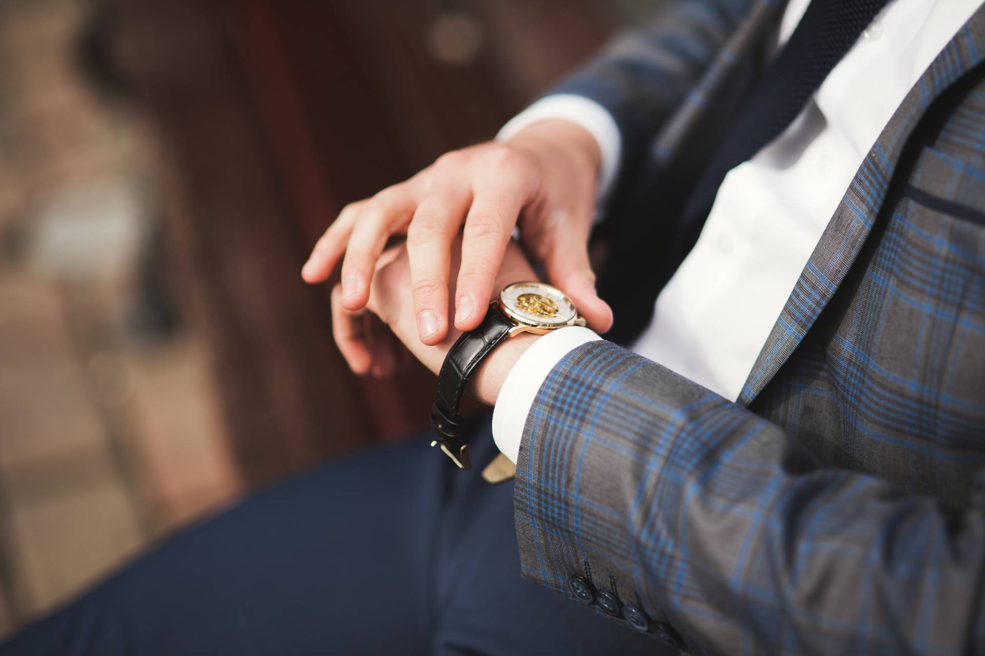 Confident businessman looking on his wrist watch in suit