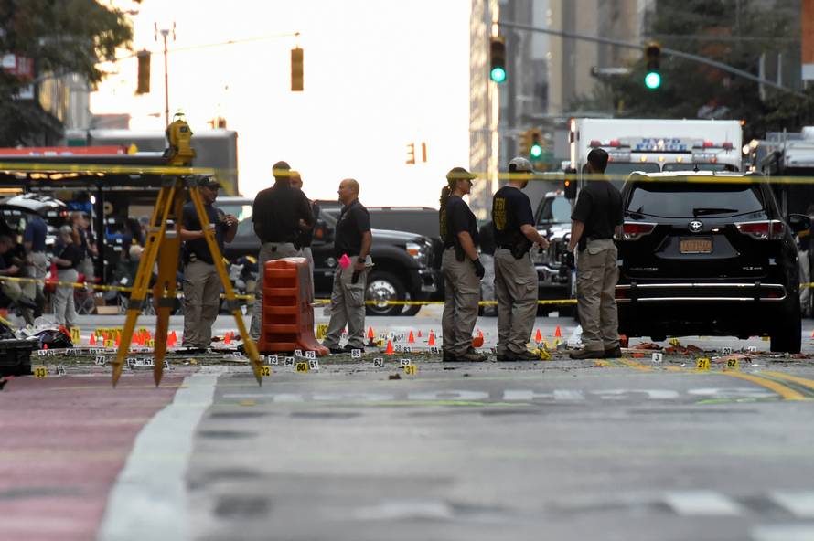 Evidence markers on the street surround FBI officials near site of  explosion in New York