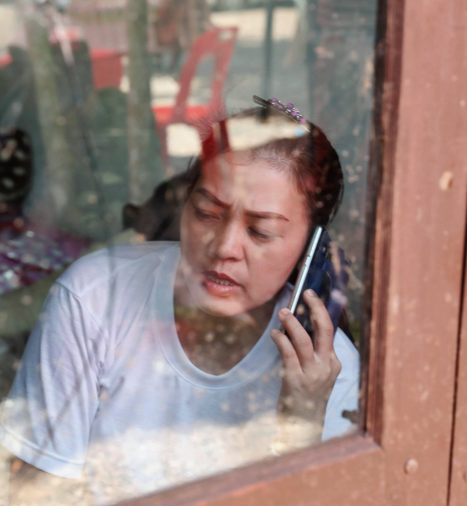 A family member talks on the phone near the Tham Luang cave complex, as members of an under-16 soccer team and their coach have been reported by local media to be found alive, in Chiang Rai