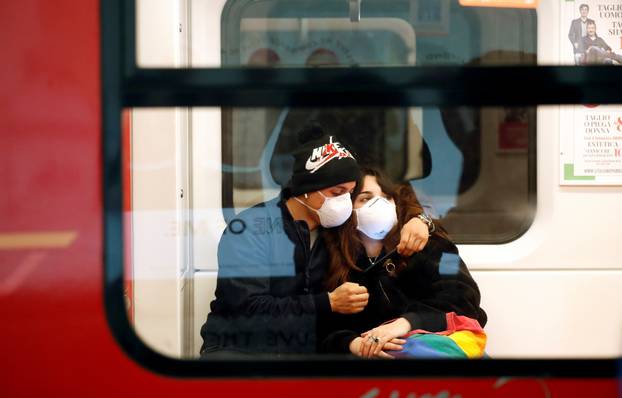 Couple wearing face masks is seen in the subway in Duomo underground station in Milan