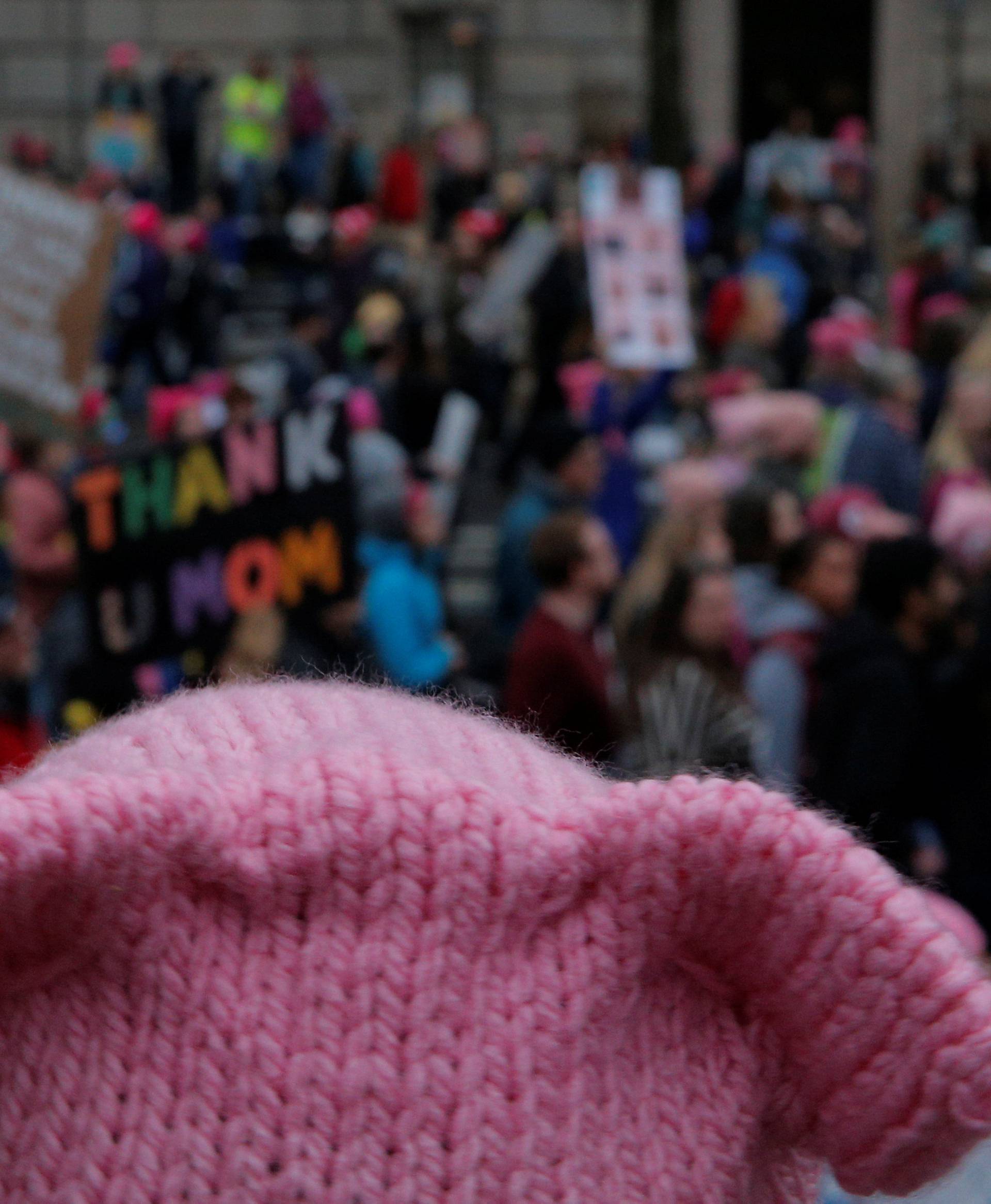 A woman wearing pink pussy protest hat watches the Women's March on Washington, following the inauguration of U.S. President Donald Trump, in Washington