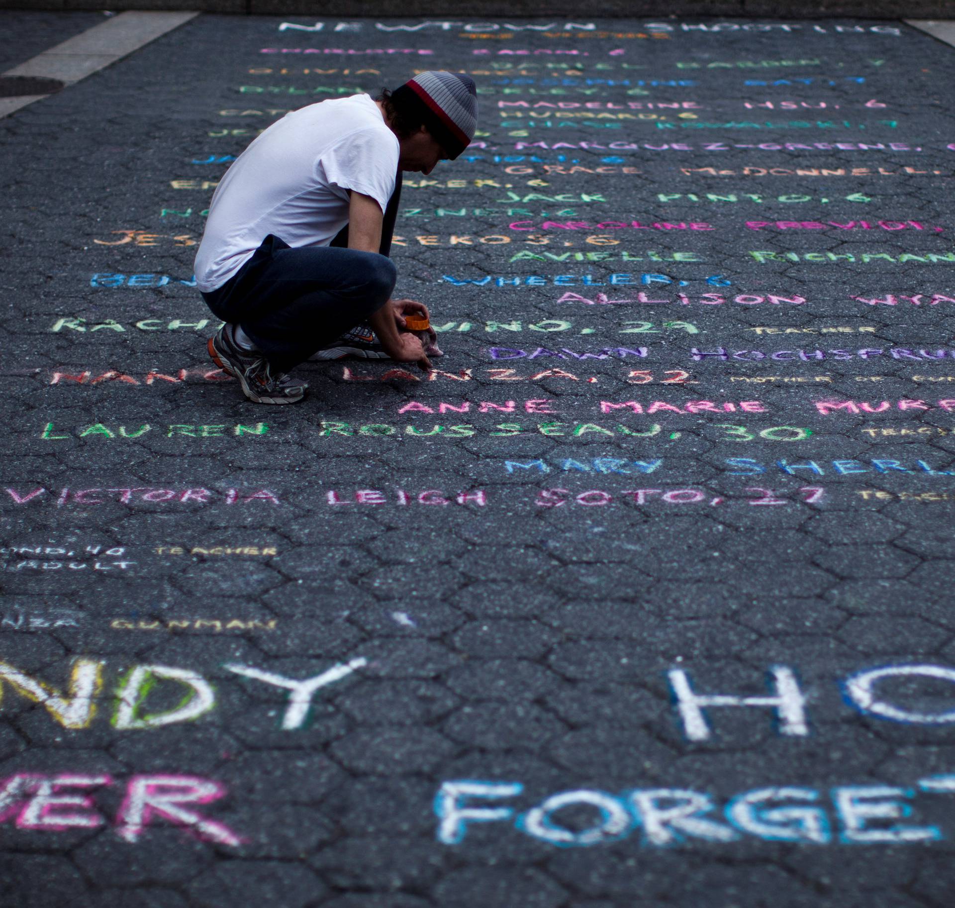 FILE PHOTO: Street artist Panzarino prepares a memorial as he writes the names of the Sandy Hook Elementary School victims during the six-month anniversary of the massacre, at Union Square in New York