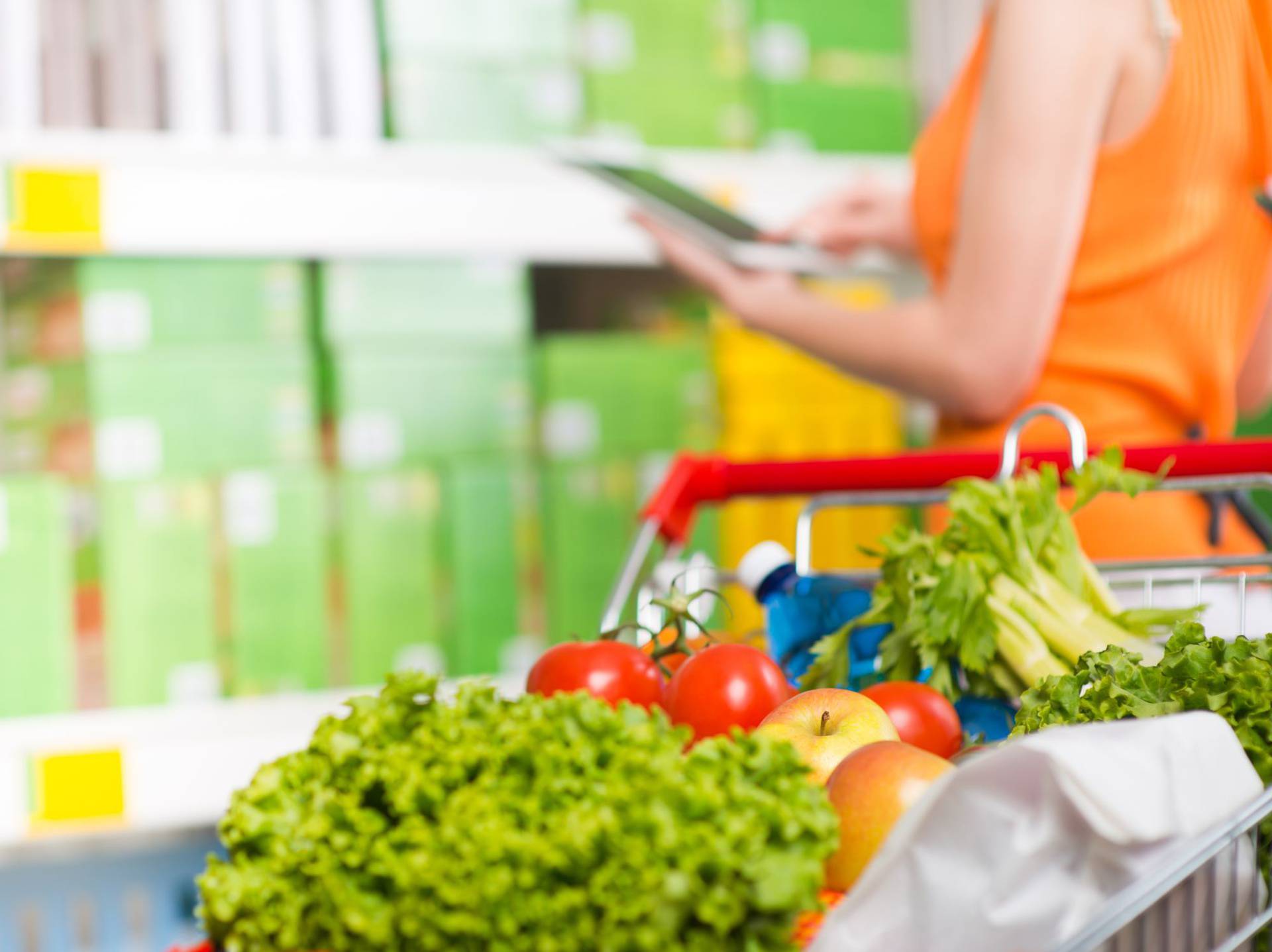 Woman,Using,Tablet,At,Store,With,Grocery,On,Foreground.