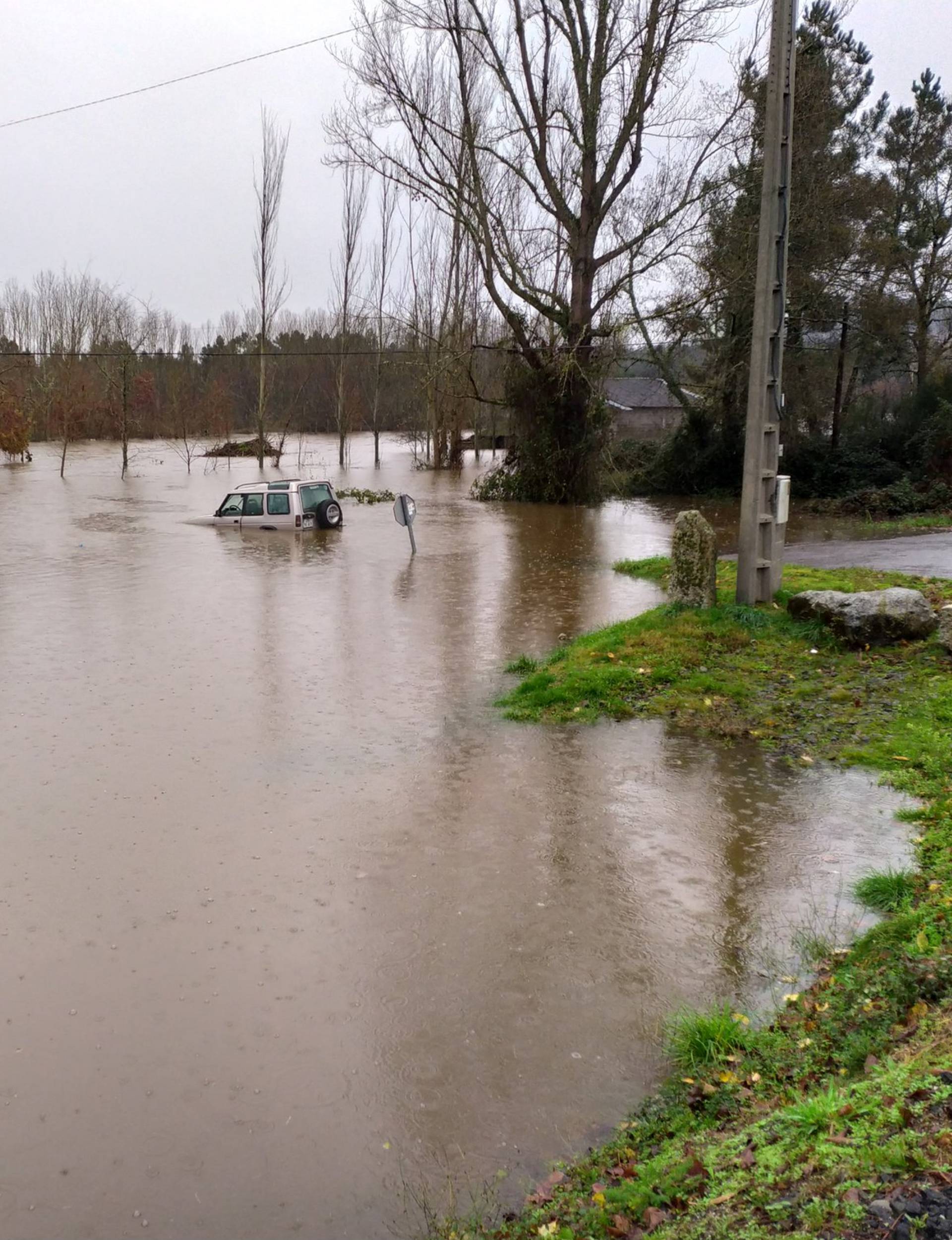 A car sits in floodwater after Storm Elsa swept throughout Galicia, in the province of Ourense