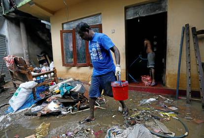 A man cleans his house which was affected by the floods in Biyagama, Sri Lanka