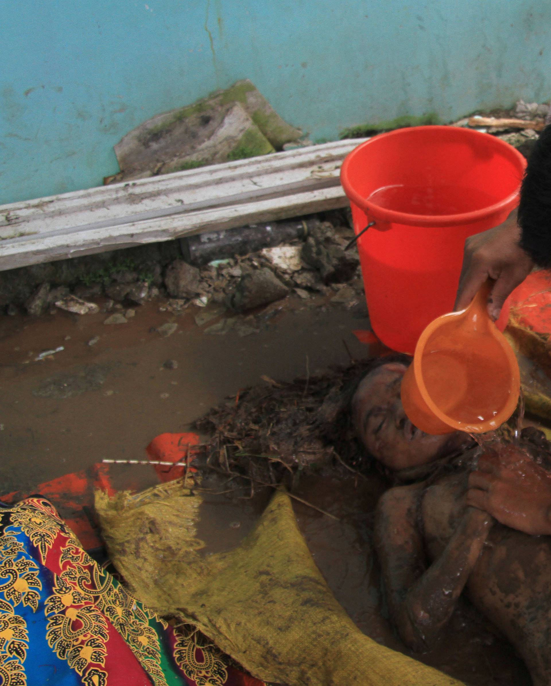 Man pours water on the body of his child after flash floods in Salvador, Lanao del Norte