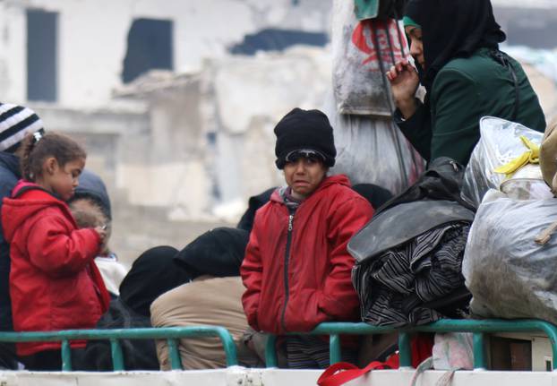 A child reacts while waiting with others to be evacuated from a rebel-held sector of eastern Aleppo