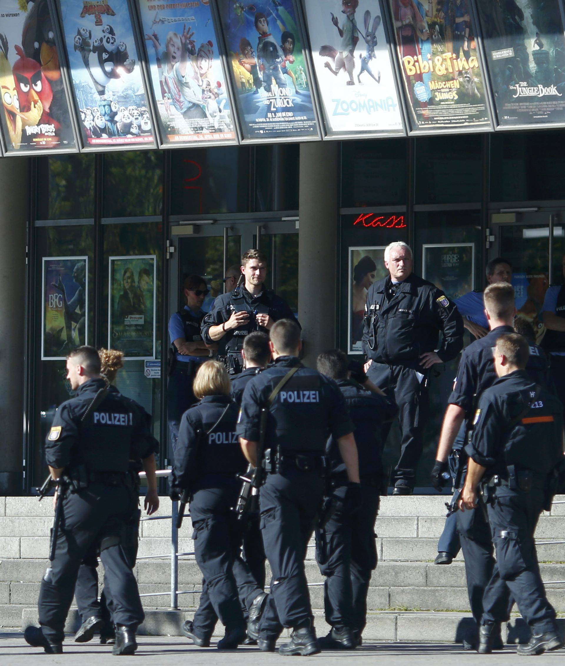 German police walks past a cinema complex after a masked man with a gun and ammunition belt opened fire in Viernheim
