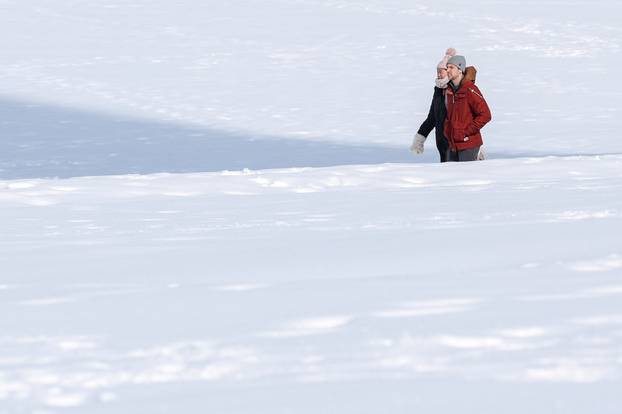 People walk through snow along the National Mall after a winter storm in Washington