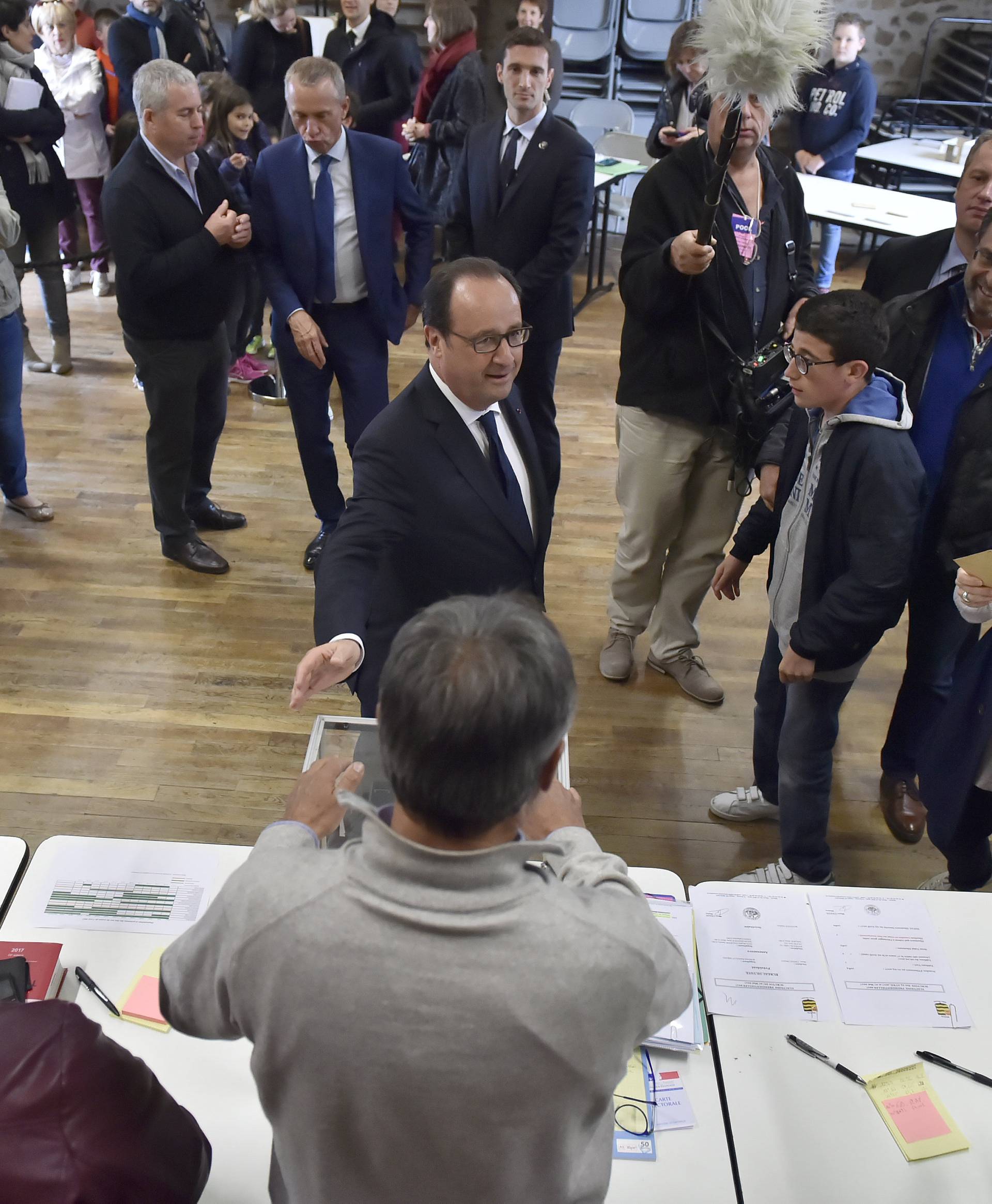 French President Francois Hollande talks with people as he visits a polling station in the village of Saint Mexant during the second round of the 2017 French presidential election