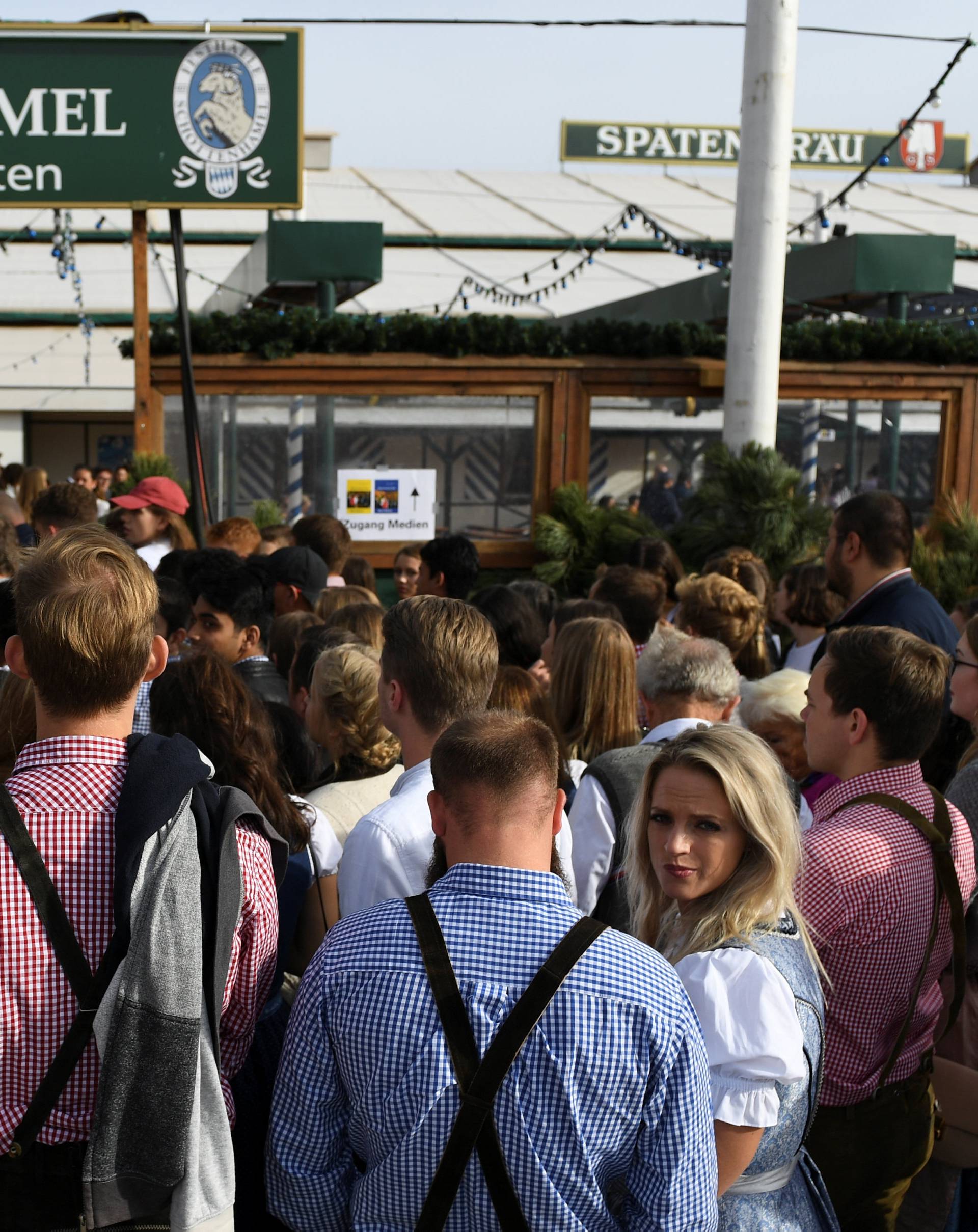 Visitors queue as they wait to enter the tent at the opening day of the 185th Oktoberfest in Munich