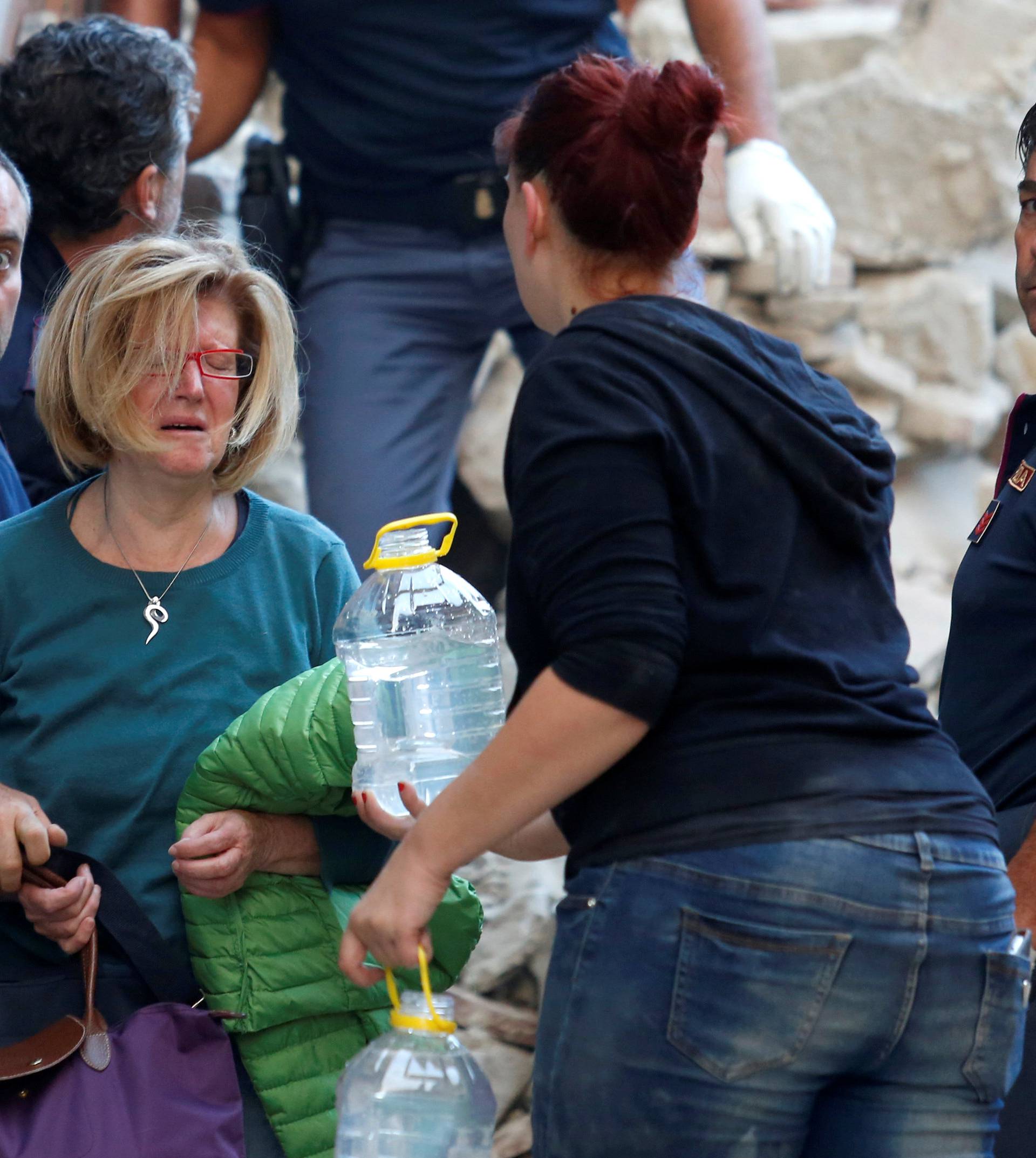 A woman cries after been rescued from her home following a quake in Amatrice