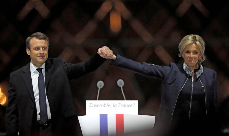 French President elect Emmanuel Macron and his wife Brigitte Trogneux celebrate on the stage at his victory rally near the Louvre in Paris