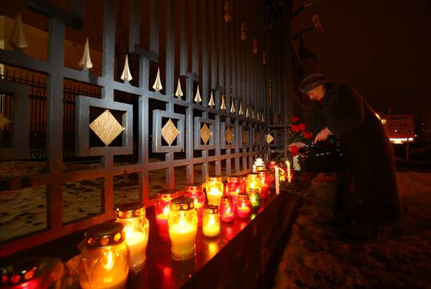 A woman lays flowers in memory of passengers and crew members of Russian military Tu-154 plane, which crashed into the Black Sea, at the Russian embassy in Minsk, Belarus