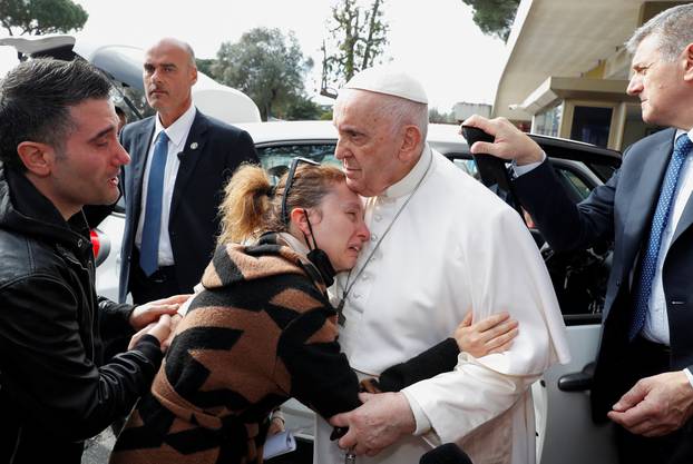 Pope Francis waves from a car as he leaves Rome's Gemelli hospital in Rome