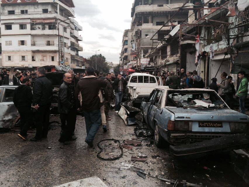 People inspect the damage at the site of a car bomb explosion, in the centre of the Syrian town of Jableh in the coastal Mediterranean province of Latakia