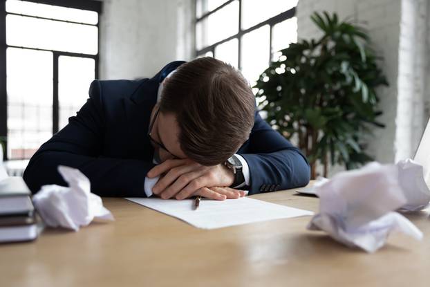 Exhausted businessman fall asleep on desk in office