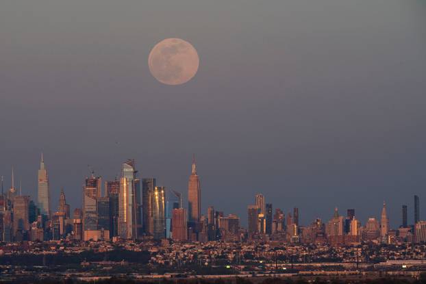 The full moon, known as the "Super Pink Moon", rises over the skyline of New York and Empire State Building, as seen from West Orange, in New Jersey