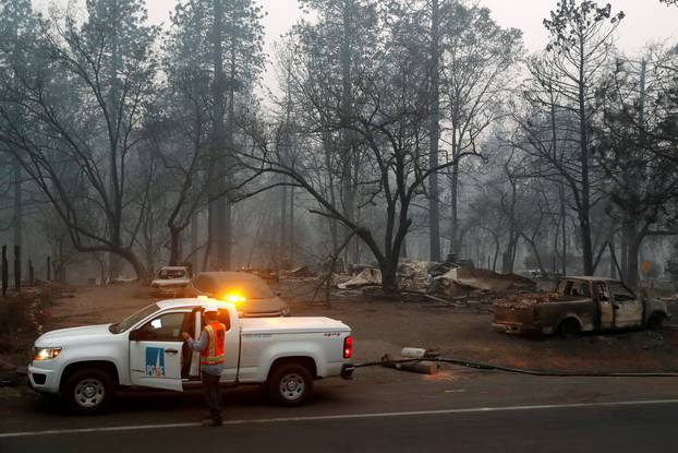 FILE PHOTO: Employees of Pacific Gas & Electric work in the aftermath of the Camp Fire in Paradise