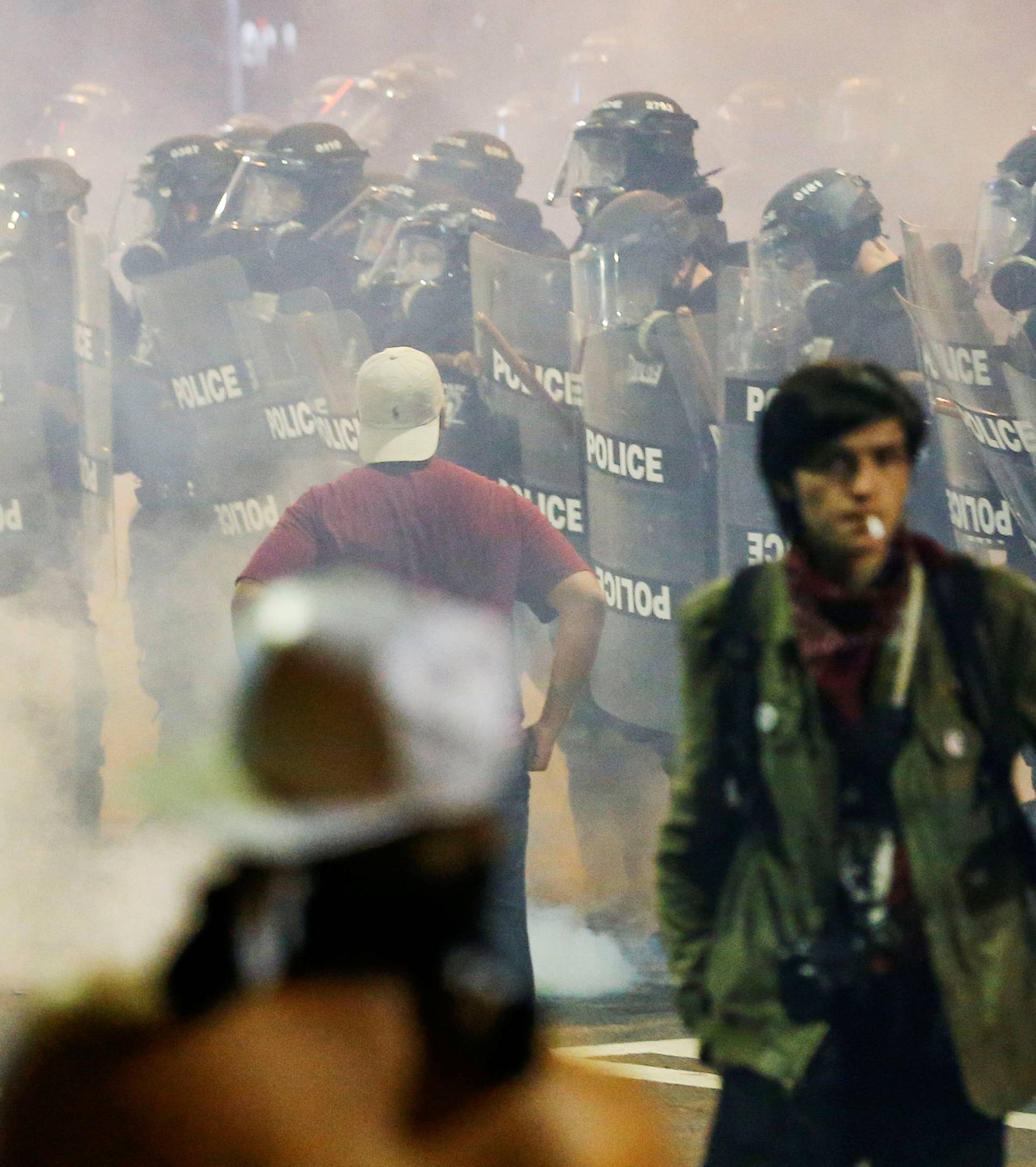 People maneuver amongst tear gas in uptown Charlotte, NC during a protest of the police shooting of Keith Scott, in Charlotte