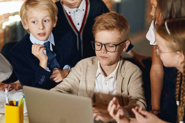 little active children watching cartoons during the break at school