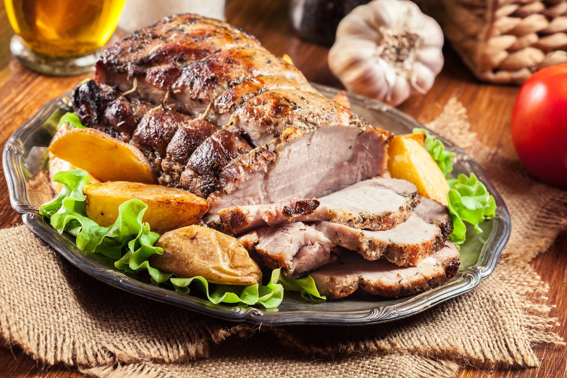 Roasted pork loin with baked potatoes and herbs