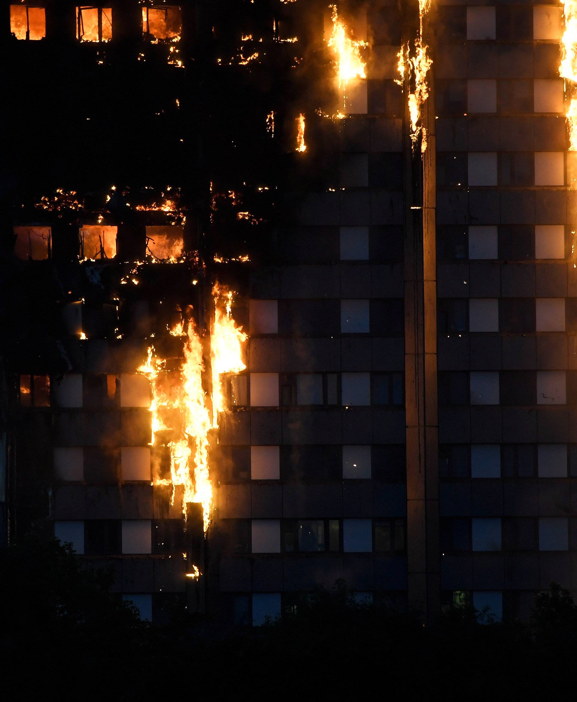 Flames and smoke billow as firefighters deal with a serious fire in a tower block at Latimer Road in West London