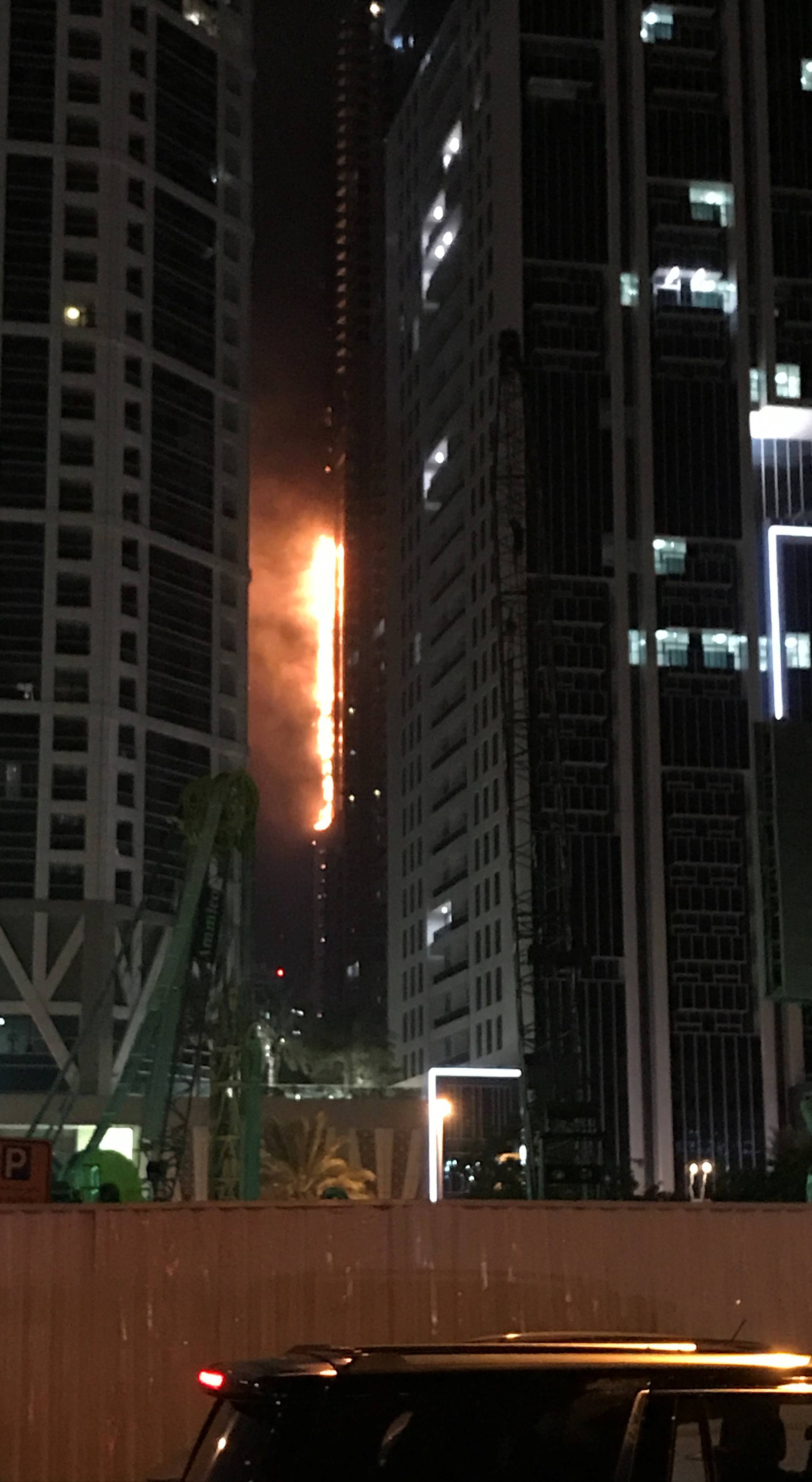 Flames shoot up the side of the Torch tower residential building in the Marina district, Dubai