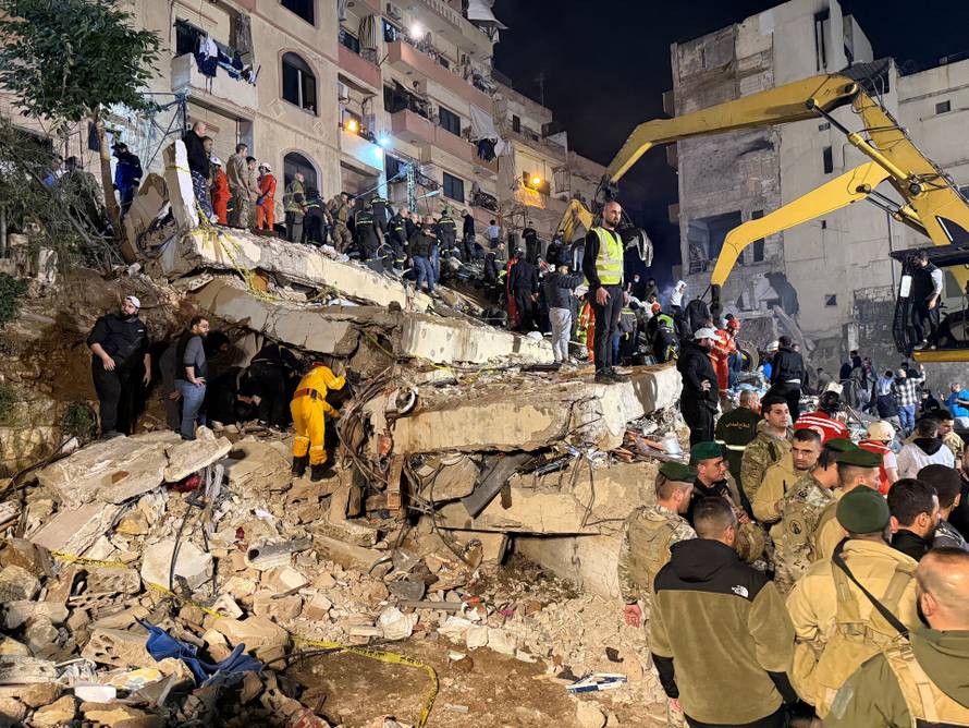 Rescue teams search for survivors after a building collapsed in Tripoli