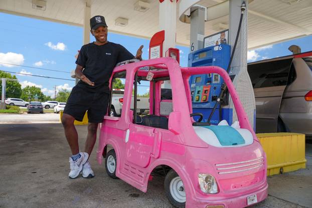Mali Hightower poses with a pink Power Wheels Barbie Dream Camper outside a gas station in Ellenwood