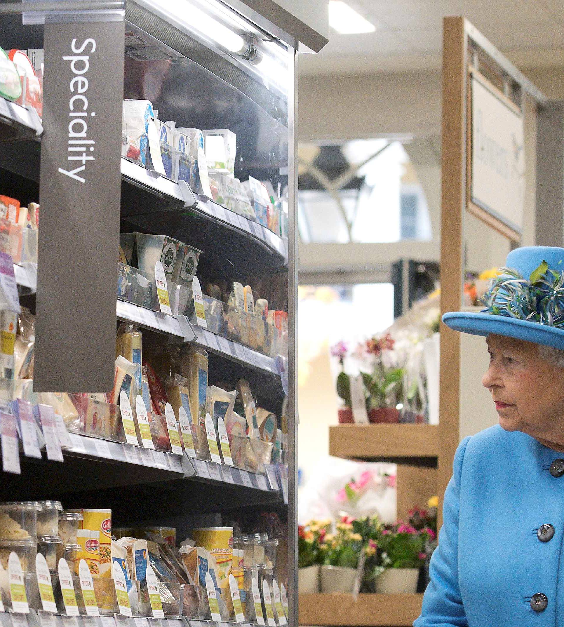 Britain's Queen Elizabeth looks at products on the shelves at a Waitrose supermarket during a visit  to the town of Poundbury