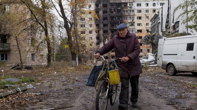 FILE PHOTO: Local resident walks in front of damaged residential buildings in Avdiivka